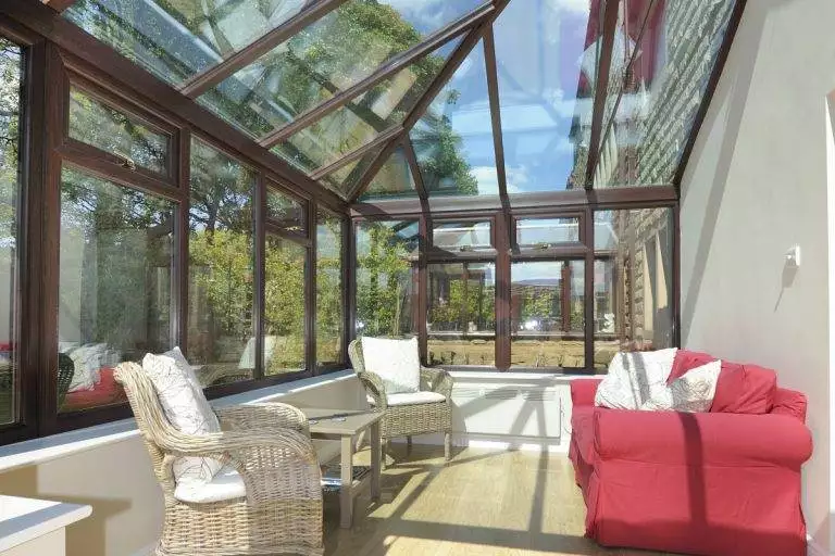 Bright conservatory with glass roof replacement and timber frame design, creating a modern living space – Cristal Windows, Doors & Conservatories