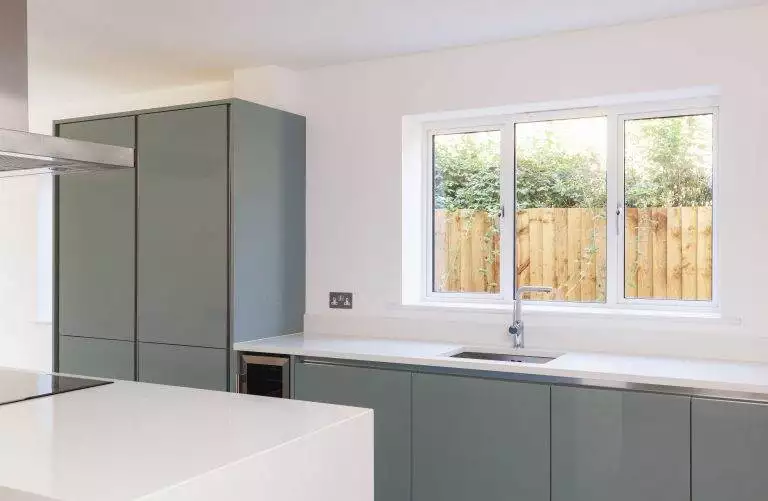 Modern white aluminium kitchen window with slim frames above a minimalist sink – Cristal Windows, Doors & Conservatories
