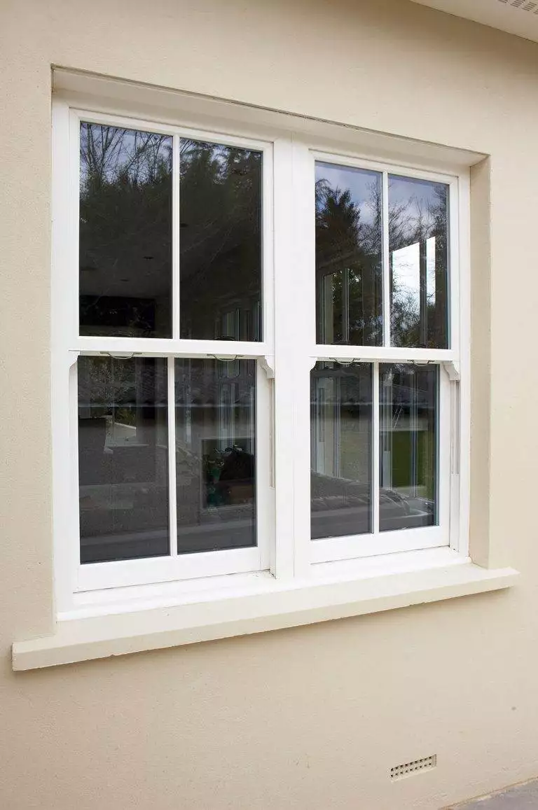 White uPVC sliding sash window with slimline astragal bars on a cream rendered exterior – Cristal Windows, Doors & Conservatories