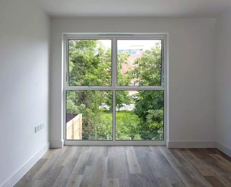 Large aluminium window with slimline frames, offering unobstructed views of greenery and maximum natural light – Cristal Windows, Doors & Conservatories