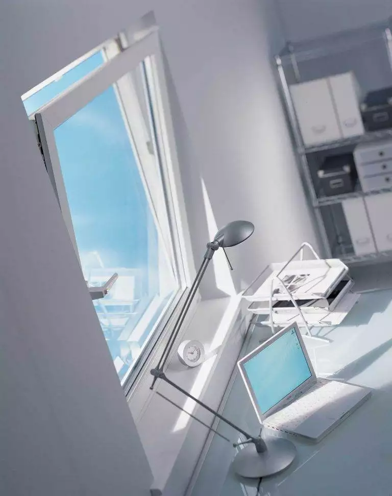 White uPVC tilt and turn window in a modern home office, shown tilted open beside a desk with a laptop – Cristal Windows, Doors & Conservatories
