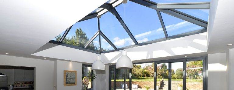 Interior view of glass roof lantern with black frame filling modern living space with natural light – Cristal Windows, Doors & Conservatories