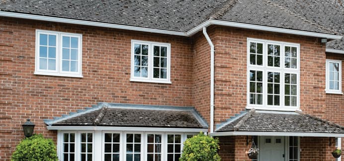 White uPVC flush casement windows with Georgian bars on a traditional red brick home – Cristal Windows, Doors & Conservatories
