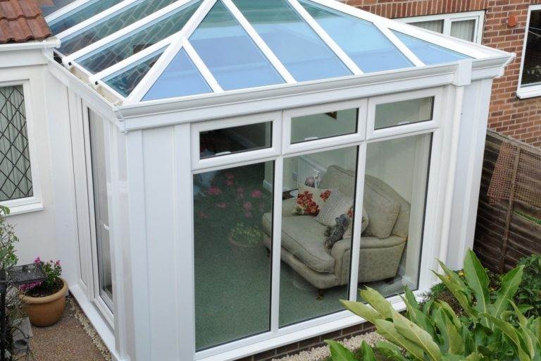 Conservatory roof replacement with modern glass panels and white uPVC frame for a bright living space – Cristal Windows, Doors & Conservatories