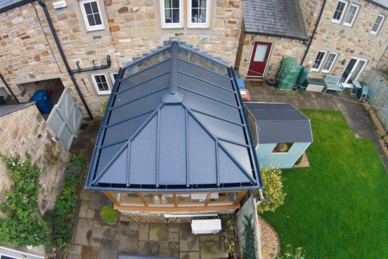 Conservatory roof replacement with modern grey tiled design on stone house extension – Cristal Windows, Doors & Conservatories