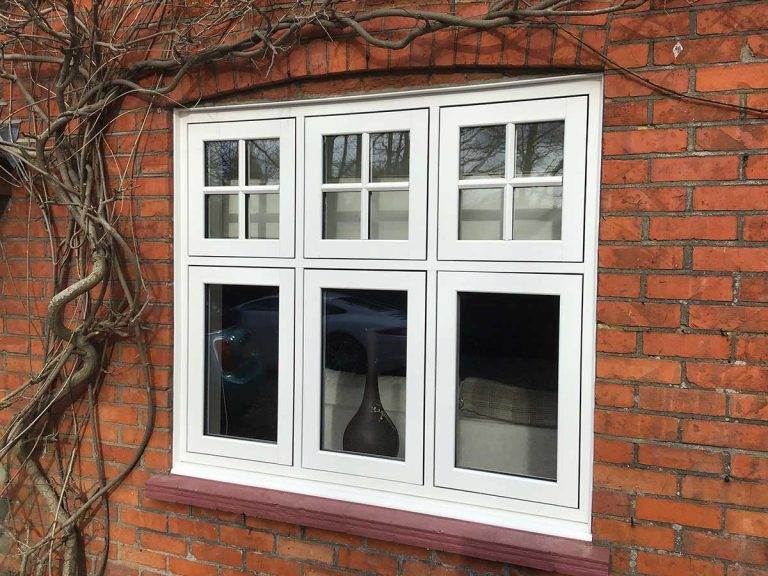 White uPVC casement window with Georgian bars on upper panes, set in a red brick wall - Cristal Windows, Doors & Conservatories