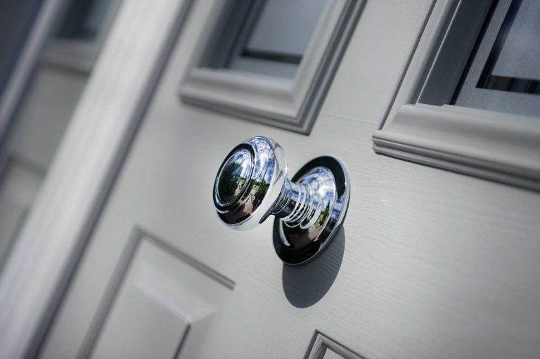 Close-up of chrome door knob on grey composite front door with decorative glazing – Cristal Windows, Doors & Conservatories