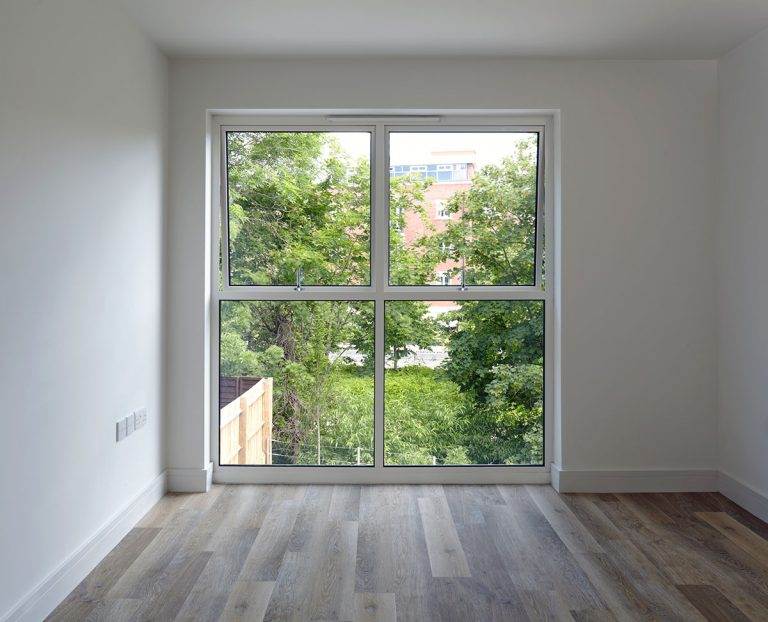Large aluminium window with slimline frames, offering unobstructed views of greenery and maximum natural light – Cristal Windows, Doors & Conservatories