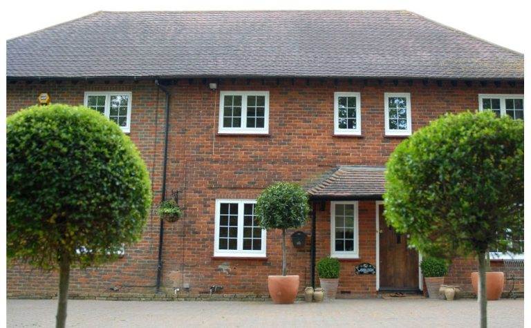 Traditional brick home featuring sleek white aluminium windows for enhanced durability and modern energy efficiency – Cristal Windows, Doors & Conservatories