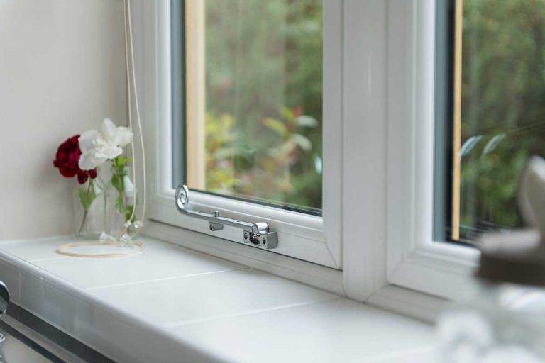 Interior view of white uPVC double glazed window with chrome handle and tiled windowsill - Cristal Windows, Doors & Conservatories