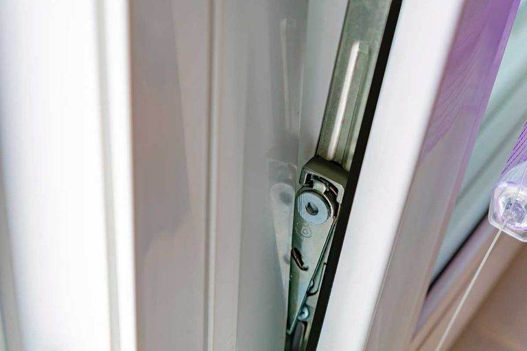 Close-up of tilt and turn window hinge mechanism on a white uPVC frame – Cristal Windows, Doors & Conservatories