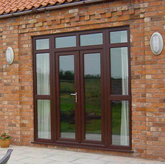 Brown uPVC French doors with side and top panels in a brick exterior – Cristal Windows, Doors & Conservatories