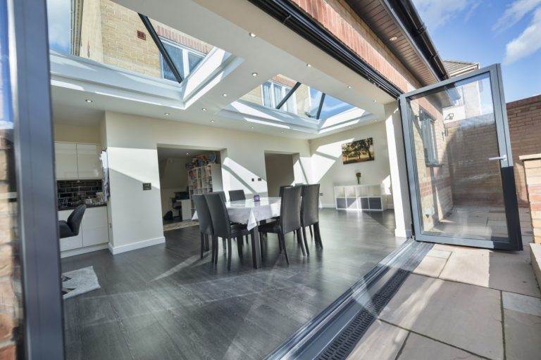 Dining room extension with double roof lanterns and bi-fold doors for a light-filled modern space – Cristal Windows, Doors & Conservatories