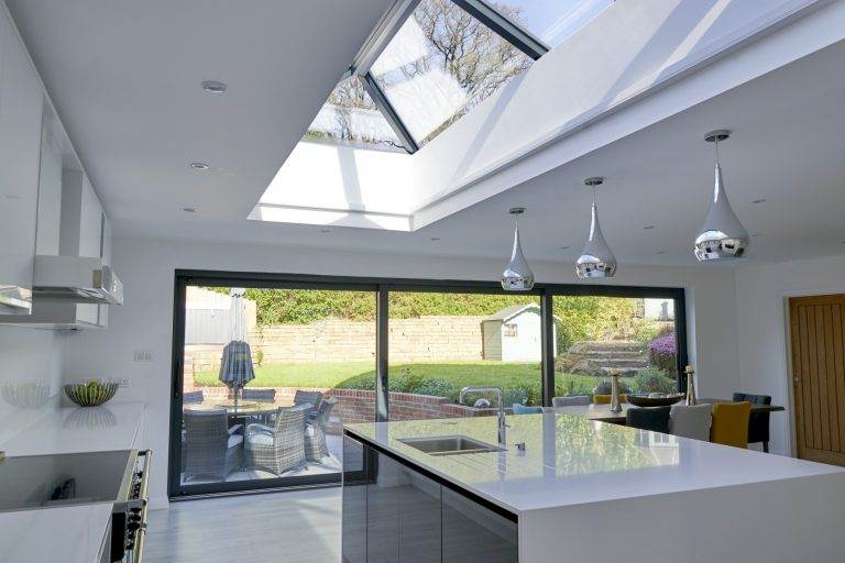 Modern kitchen extension with glass roof lantern and sliding doors filling the space with natural light – Cristal Windows, Doors & Conservatories