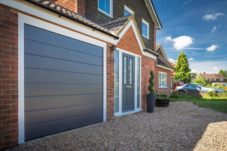 Modern family home with a sleek grey sectional garage door and matching front entrance door – Cristal Windows, Doors & Conservatories