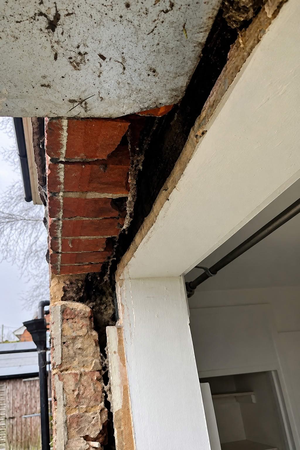An opening with the old frame removed, revealing no adequate support above