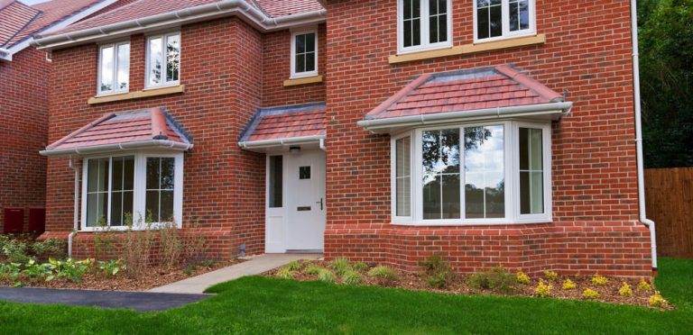 Modern red brick house with a white uPVC residential front door and matching bay windows – Cristal Windows, Doors & Conservatories