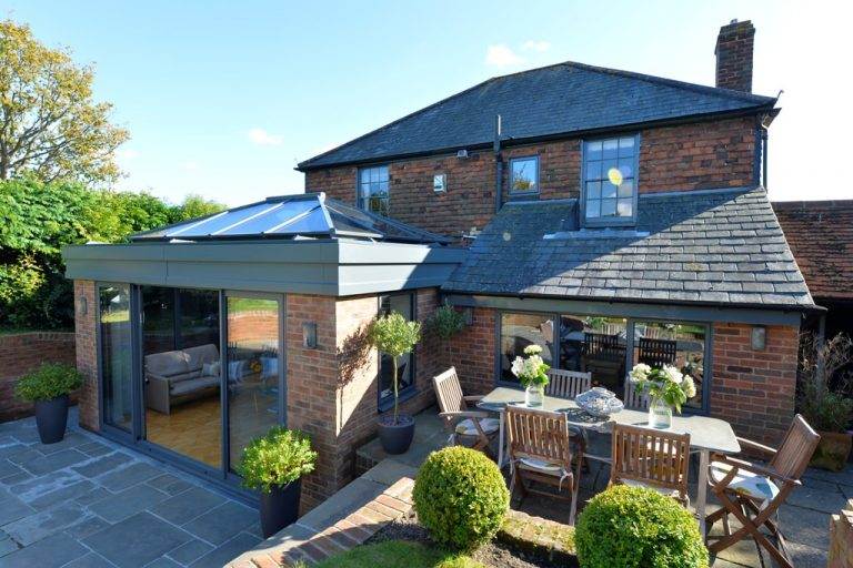 Stylish conservatory roof replacement with lantern glass roof and brick extension design – Cristal Windows, Doors & Conservatories