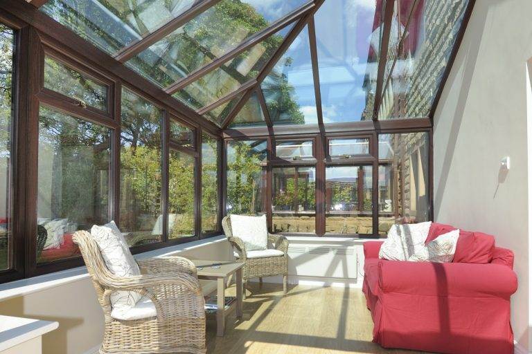 Bright conservatory with glass roof replacement and timber frame design, creating a modern living space – Cristal Windows, Doors & Conservatories