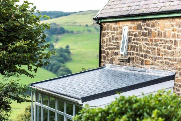 Modern conservatory roof replacement with sleek tiled design on stone house extension – Cristal Windows, Doors & Conservatories