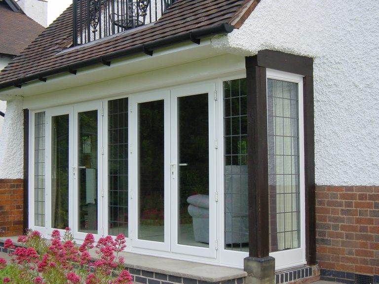 White uPVC French doors with decorative grid design opening to the garden – Cristal Windows, Doors & Conservatories