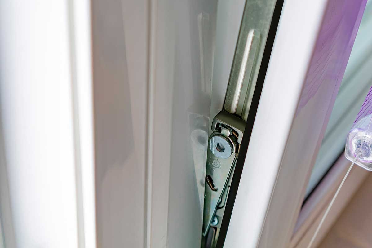 Close-up of tilt and turn window hinge mechanism on a white uPVC frame – Cristal Windows, Doors & Conservatories