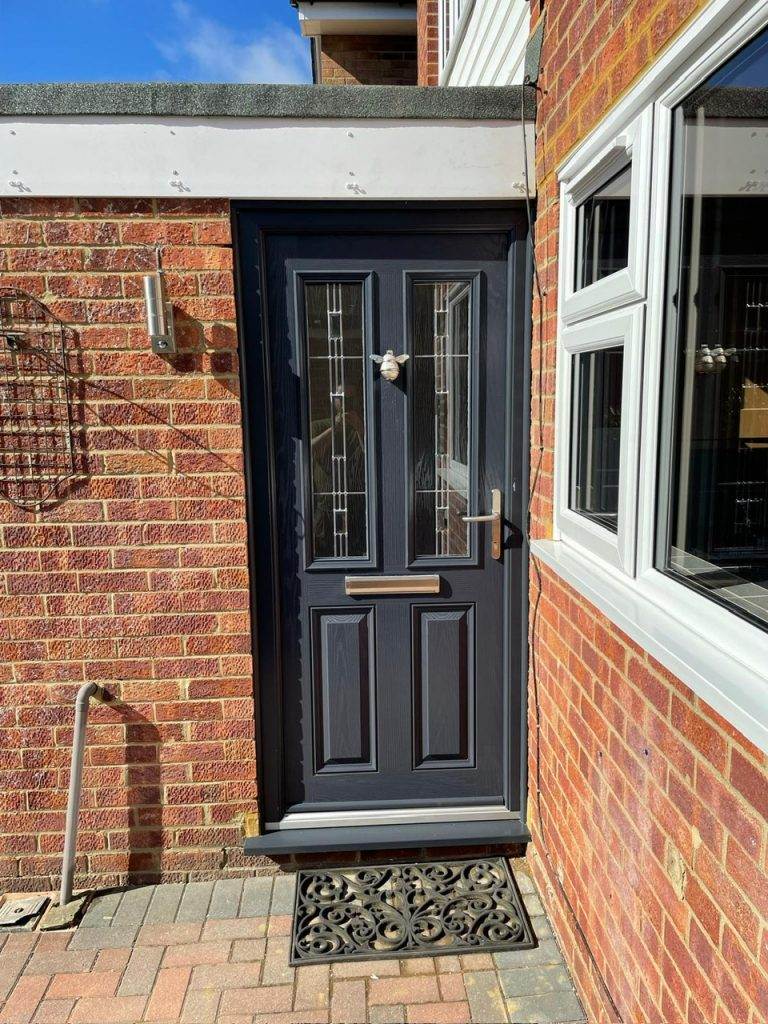 Grey composite front door with decorative glass installed by Cristal Windows