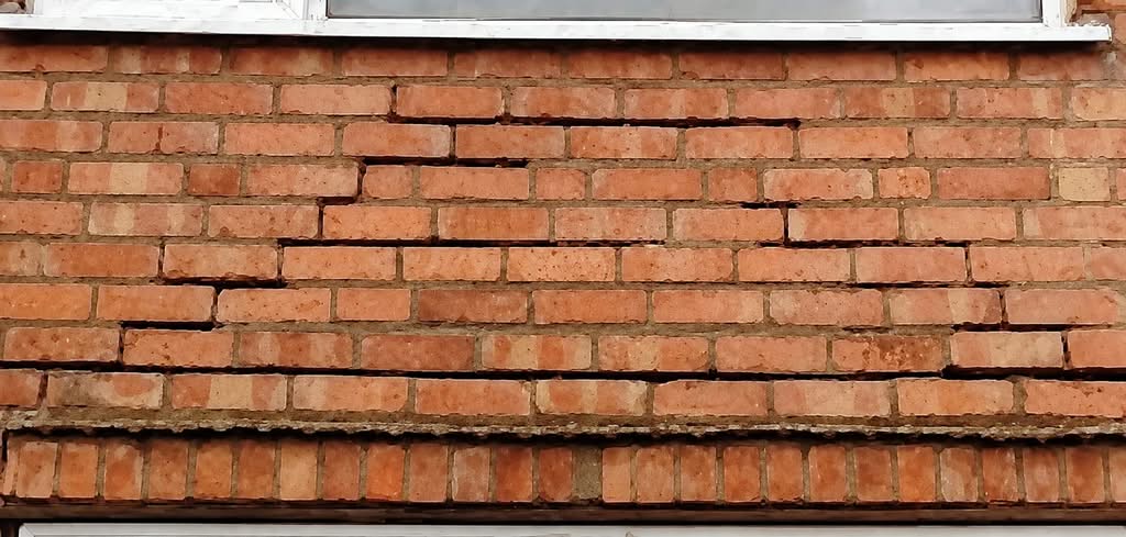 Brickwork above a window head that has dropped and cracked where the frame was carrying the load